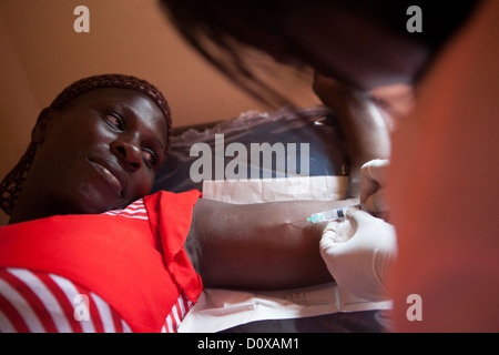 Une femme reçoit un implant contraceptif dans un centre de santé sur l'île de Bussi, Ouganda, Afrique de l'Est. Banque D'Images