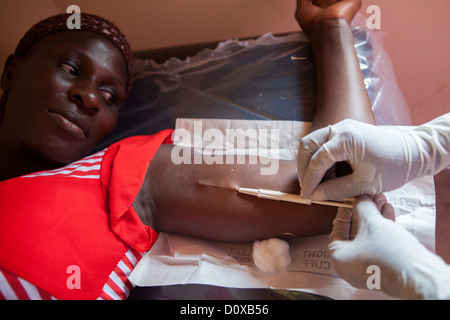 Une femme reçoit un implant contraceptif dans un centre de santé sur l'île de Bussi, Ouganda, Afrique de l'Est. Banque D'Images