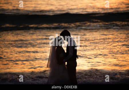 Couple de mariés, mariés, silhouetté à Surin Beach, près de Surin Beach, Phuket, Thaïlande Banque D'Images