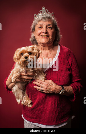 Senior woman holding dog et portant une tiare Banque D'Images