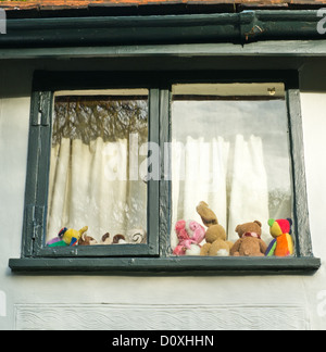 Une ligne de jouets pour enfants est la fenêtre d'une maison in Debenham Suffolk. Banque D'Images