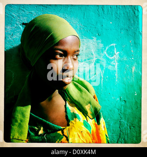 Portrait d'une jeune femme avec des vêtements colorés posant devant un mur vert, Harar, en Ethiopie Banque D'Images