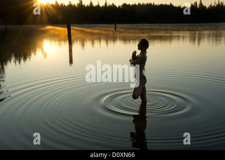 Femme méditant dans lac calme Banque D'Images