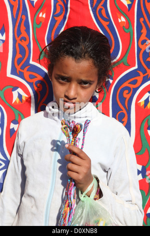 DAHAB - JANVIER 23. Jeune vendeur de rue exhibant ses bracelets à Dahab, Egypte. Il fournit un revenu pour leur famille. Banque D'Images