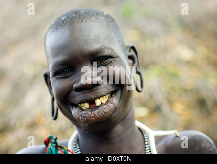 Portrait d'une femme de la tribu Surma avec lèvre élargie et les oreilles et sourire à pleines dents, vallée de l'Omo, Ethiopie Banque D'Images