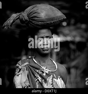 Portrait noir et blanc d'une tribu Bodi femme portant un sac sur sa tête, Hana Mursi, vallée de l'Omo, Ethiopie Banque D'Images