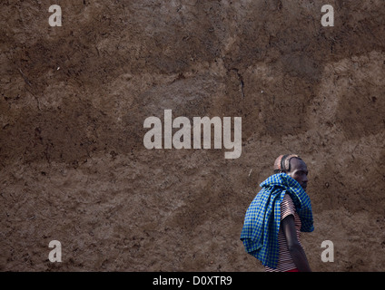 L'homme de la tribu de Hamar en passant par un mur de boue, Turmi, vallée de l'Omo, Ethiopie Banque D'Images