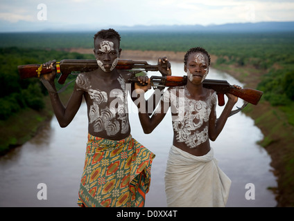 Les garçons de la tribu Karo avec peinture Corps et Kalachnikovs posant sur la rivière Omo, Korcho Village, vallée de l'Omo, Ethiopie Banque D'Images