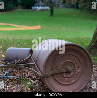 Cockington, Devon, Angleterre. Le 30 novembre 2013. Un grand rouleau d'herbe avec le pavillon du terrain de cricket et à l'arrière-plan. Banque D'Images