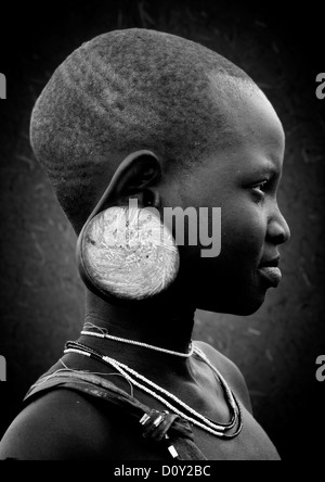 Profil noir et blanc Portrait d'une jeune fille de la tribu Mursi avec grande oreille, avec la plaque de l'oreille, vallée de l'Omo, Ethiopie Banque D'Images