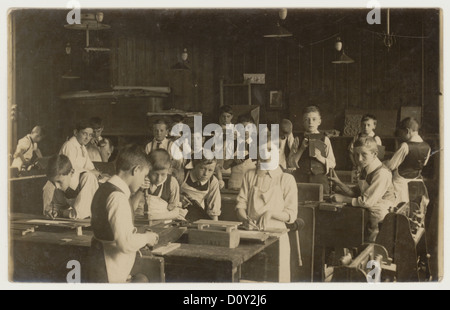 Original du début des années 1900 photographie victorienne ou édouardienne de jeunes écoliers édouardiens dans une classe de menuiserie, du studio de Montague Cooper, Somerset, Angleterre, Royaume-Uni vers 1910 Banque D'Images