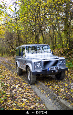 Land Rover Defender off road à l'automne la forêt, Herefordshire, Angleterre, RU Banque D'Images