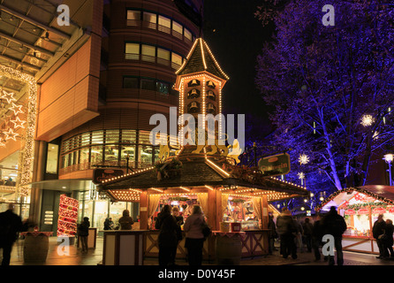 Les étals du marché traditionnel de Noël éclairé la nuit avec des gens du shopping à Potsdamer Platz, Berlin city, Allemagne Banque D'Images