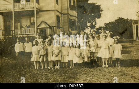 Circa 1890 Carte du cabinet photo, un groupe d'enfants à l'extérieur une grande maison Victorienne, probablement la Nouvelle Angleterre, USA. Banque D'Images