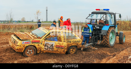 Le démarrage du tracteur pour remorquer la voiture de course sur route sale endommagé. Banque D'Images