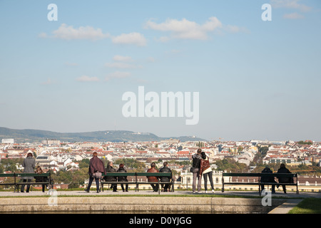 Dans les jardins de Schönbrunn'couples et amis s'asseoir, de prendre des photos, s'ouvrent sur la ville de Vienne sous ciel nuageux ciel bleu. Banque D'Images