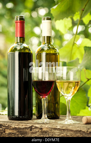 Des bouteilles de vin rouge et blanc et deux verres Banque D'Images