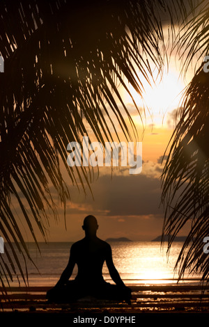 Silhouette de l'homme faisant l'exercice de yoga Banque D'Images