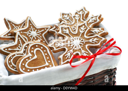 Gingerbread cookies décorés de glaçage royal disposés dans un panier sur un fond blanc. Banque D'Images