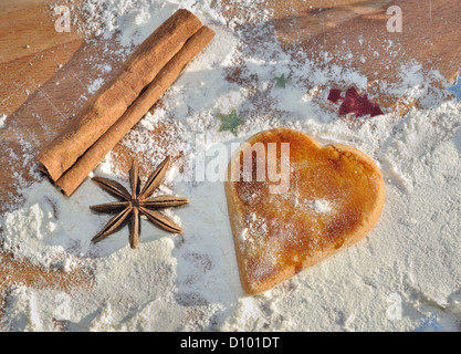Coeur en forme de sablés pour Noël sur la farine et avec quelques épices Banque D'Images