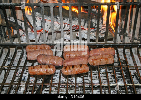 Saucisses de porc cuit sur les braises de l'incendie Banque D'Images