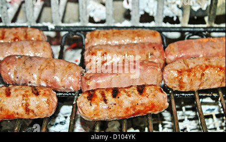 Saucisses de porc cuit sur les braises de l'incendie Banque D'Images