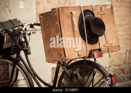 Shabby black hat et brown valise sur le vieux vélo. Et de style rétro image sépia Banque D'Images