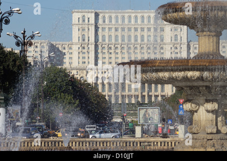 Bucarest, Roumanie, fontaines sur la place de l'unité, dans l'arrière-plan du Palais du Parlement Banque D'Images