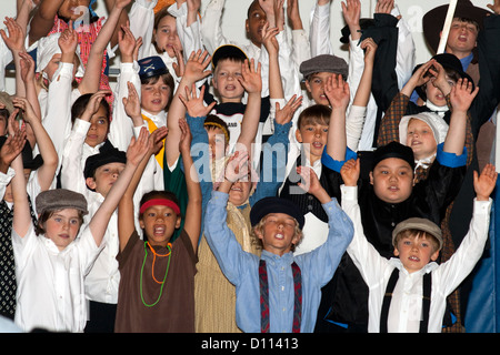 L'âge de 10 chanteurs de l'école exubérante avec les bras au-dessus de la tête dans le Minnesota historique des costumes. Horace Mann l'école. St Paul Minnesota MN USA Banque D'Images