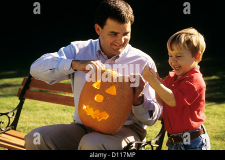 Des années 90, père et fils sculpter une citrouille d'HALLOWEEN EN PLEIN AIR Banque D'Images