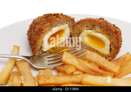 Le Scotch egg et les chips de pomme de terre avec une fourchette sur une assiette Banque D'Images