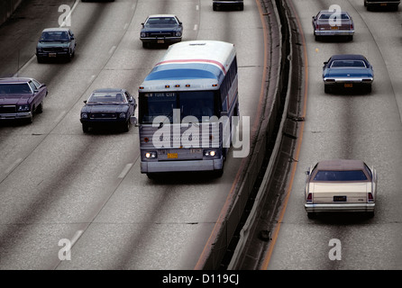 1970 VOITURES BUS trafic sur autoroute divisée Banque D'Images