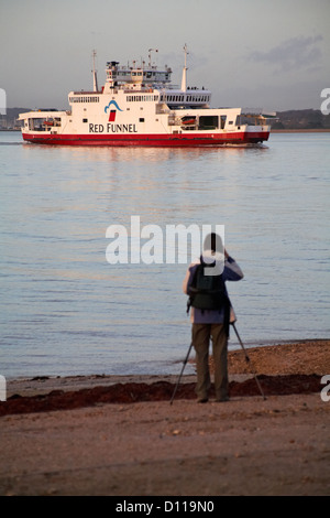 Ferry Red Funnel Osprey rouge en direction de Southampton de Cowes avec le photographe en premier plan en prenant des photos à Calshot, Hampshire en Novembre Banque D'Images