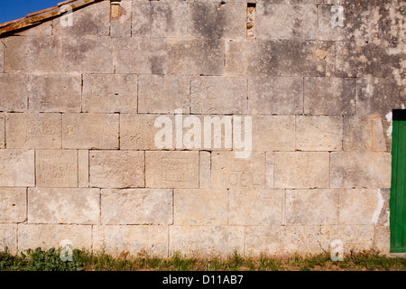 Noms des bergers creusée dans le mur de pierre d'une ancienne grange. Peau de Meau grange. Réserve Naturelle Coussouls de Crau. Provence. Banque D'Images