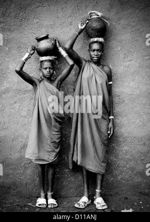 Portrait noir et blanc de femmes des tribus Bodi transportant des pots de lait sur leur tête, Hana Village Mursi, vallée de l'Omo, Ethiopie Banque D'Images