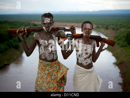 Les garçons de la tribu Karo avec peinture Corps et Kalachnikovs posant sur la rivière Omo, Korcho Village, vallée de l'Omo, Ethiopie Banque D'Images