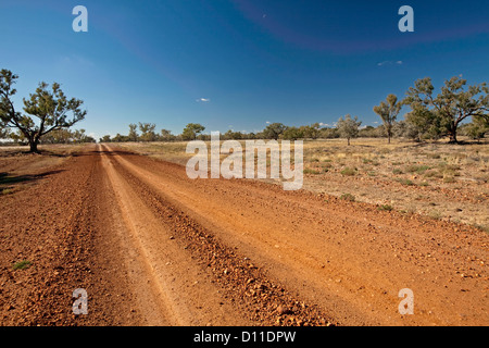 Australian Outback rouge longue route à travers un paysage désertique aride et les plaines du nord-ouest de NSW Australie Banque D'Images