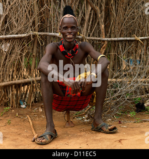 Portrait Of Smiling Man Sitting on tribu Hamar appuie-tête en Turmi, vallée de l'Omo, Ethiopie Banque D'Images