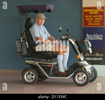 Homme âgé - pensionné - sur la mobilité électrique scooter sur city pavement en Australie Banque D'Images