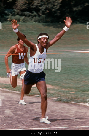 1970 COURSE À PIED PORTEUR AVEC AFRICAN AMERICAN MAN BREAKING BANDE À LIGNE D'ARRIVÉE Banque D'Images