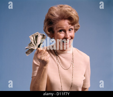 1970 SMILING MIDDLE AGED WOMAN HOLDING POIGNÉE D'ARGENT LOOKING AT CAMERA Banque D'Images