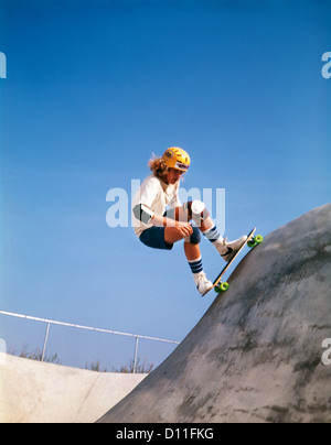 1970 TEENAGE BOY PORTANT L'ÉQUIPEMENT DE SÉCURITÉ SKATE BOARDING SUR PLANCHE PARCOURS Banque D'Images