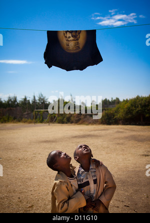 Les enfants regardant un T-shirt avec le Portrait de Haile Selassie, Shashemene Jamaican School, région d'Oromia, en Éthiopie Banque D'Images