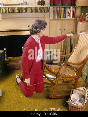 1960 Femme d'âge moyen de la bastonnade SIÈGE DE CHAISE HOBBY ART ARTISANAT RÉPARATION ACCUEIL MÉNAGE Banque D'Images