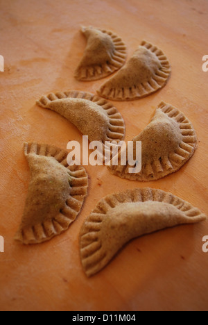 Les pâtes maison appelé ravioli rempli de fines herbes et le tofu s'appuyant sur un comptoir en bois Banque D'Images