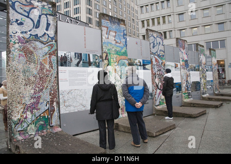 Berlin Allemagne UE visiteurs lire les détails de l'ancien mur de Berlin qui a divisé la ville avec des segments conservés Banque D'Images