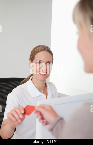 Allemagne, carte d'assurance maladie du patient à donner de réceptionniste de cabinet dentaire Banque D'Images