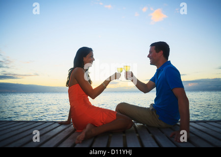 Un homme et une femme le grillage avec un verre au bord de l'eau au Bora Bora Nui Resort And Spa ; Îles de la société, Pacifique Sud Banque D'Images