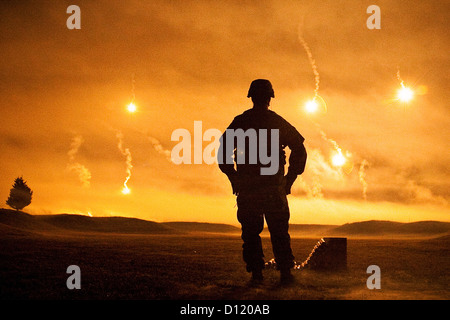 Un soldat de l'armée américaine surveille les torches illuminent le ciel pendant le ministère de l'Armée Concours Meilleur Guerrier 2011 5 octobre, 2011 à Fort Lee, New Jersey. Banque D'Images