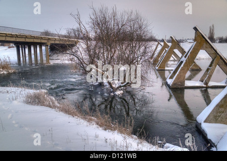 Un pont dans un quartier résidentiel sur un étang gelé Banque D'Images